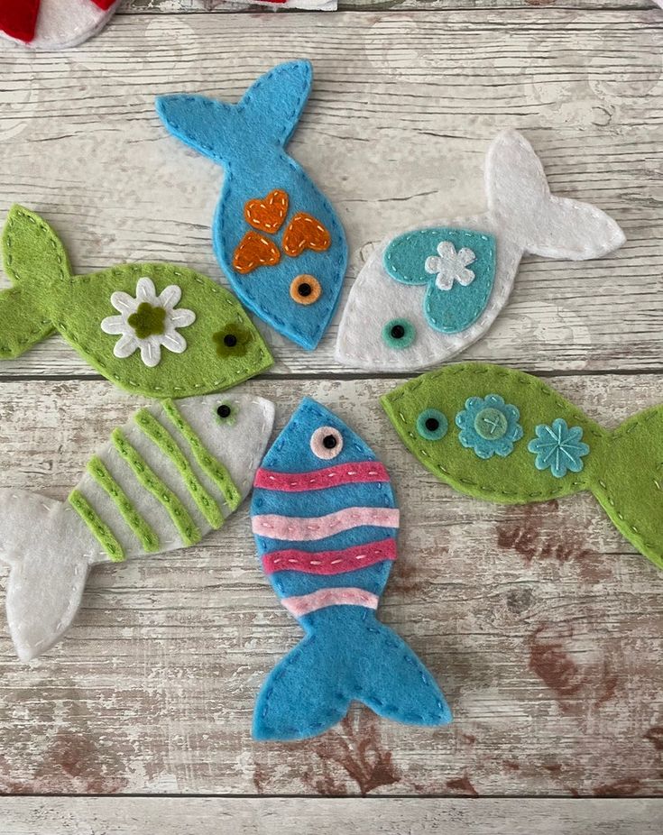 four felt fish sitting on top of a wooden table