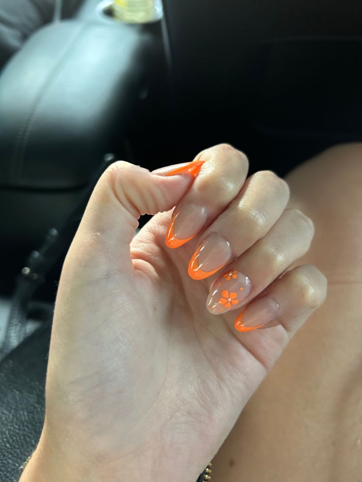 Orange Flower Acrylic Nails, Light Orange Nails With Design, Orange Flower French Tip Nails, Orange And White Almond Nails, Orange Oval Acrylic Nails, Orange French Tip With Design, Orange French Tip Nails With Flowers, Orange Graduation Nails, Orange Nails With White Flowers