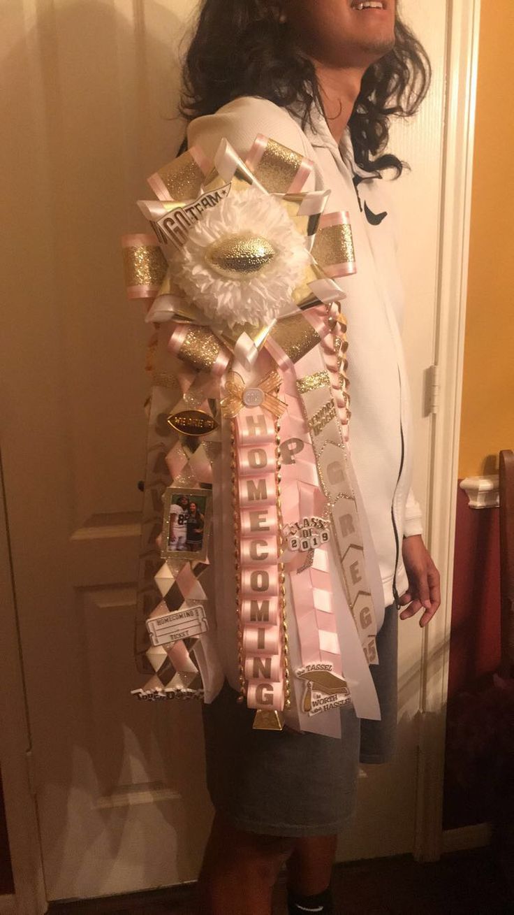 a woman standing in front of a door wearing a dress made out of ribbons and buttons