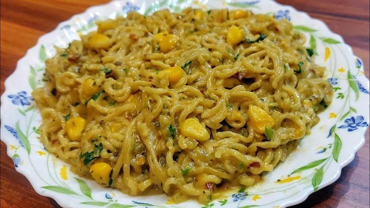 a plate filled with noodles and vegetables on top of a wooden table