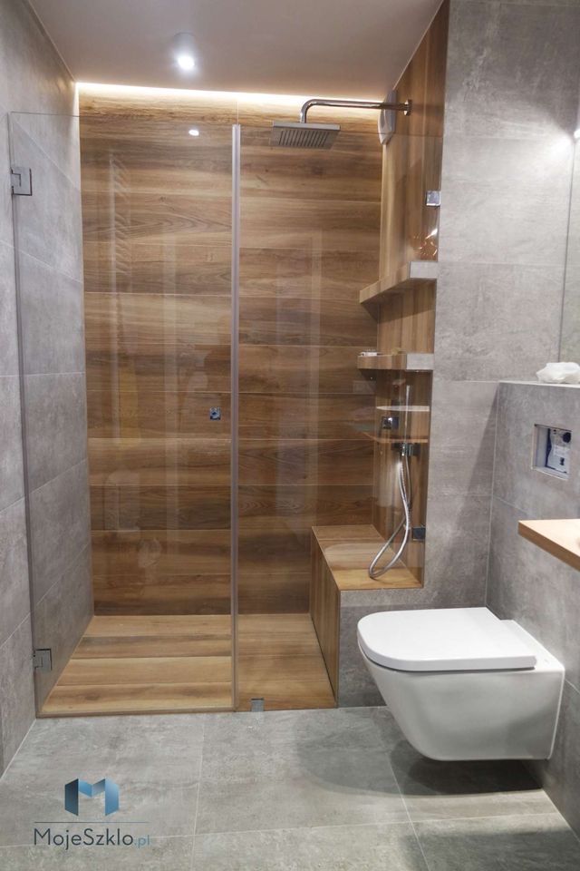 a bathroom with a toilet, shower and wooden shelves in it's corner area