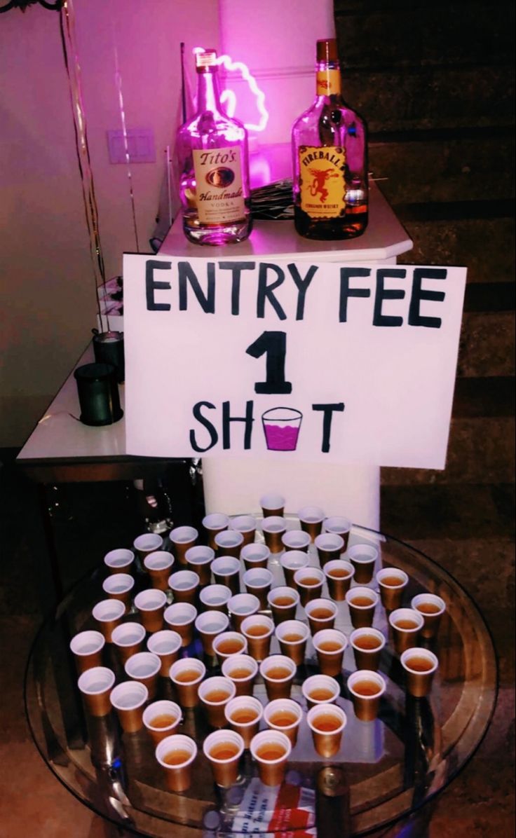 there is a sign that says entry fee 1 shot with cups in front of it