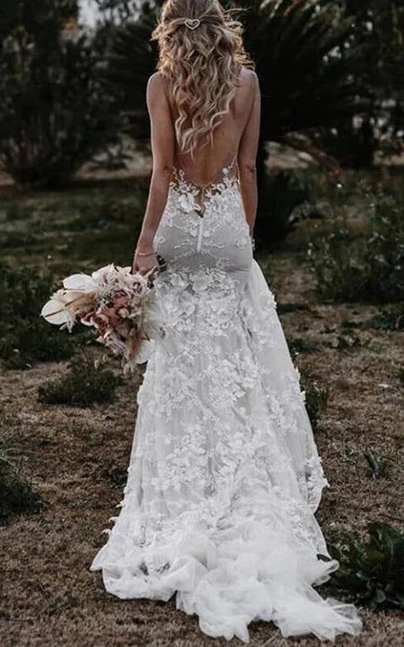 a woman in a wedding dress with flowers on her head and long blonde hair, holding a bouquet