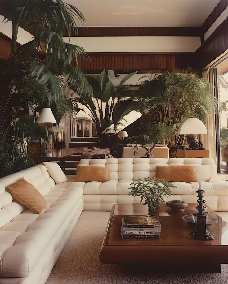 a living room filled with white couches and lots of plants on top of it