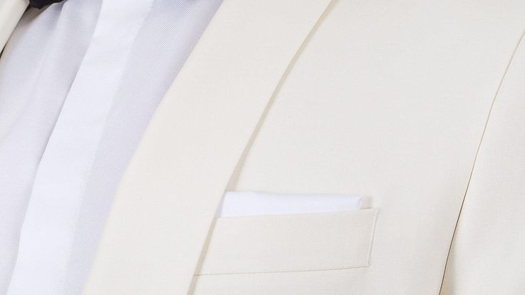 If you are seeking a formal look with a white or ivory dinner jacket to attend events in the spring & summer - or even for your special day, we recommend pairing an ivory dinner jacket with black tuxedo pants rather than going for an all-ivory tuxedo. This dinner suit features self-faced shawl collar (no satin), mother-of-pearl buttons and classic black tuxedo pants with a 10mm satin stripe on the side. 
The 100% Super 110s wool fabric woven by the Italian fabric experts Vitale Berberis Canonico Elegant Beige Tuxedo For Formal Occasions, Elegant Beige Tuxedo With Notch Lapel, Elegant Beige Formal Tuxedo, Luxury Beige Tuxedo For Business, Tailored Cream Tuxedo For Semi-formal Occasions, Luxury Beige Business Tuxedo, Luxury White Blazer For Wedding, Elegant Cream Tuxedo For Business, Cream Tuxedo Suit With Notch Lapel