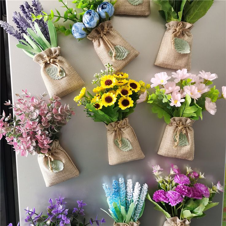 a bunch of flowers that are sitting in vases on a wall next to each other