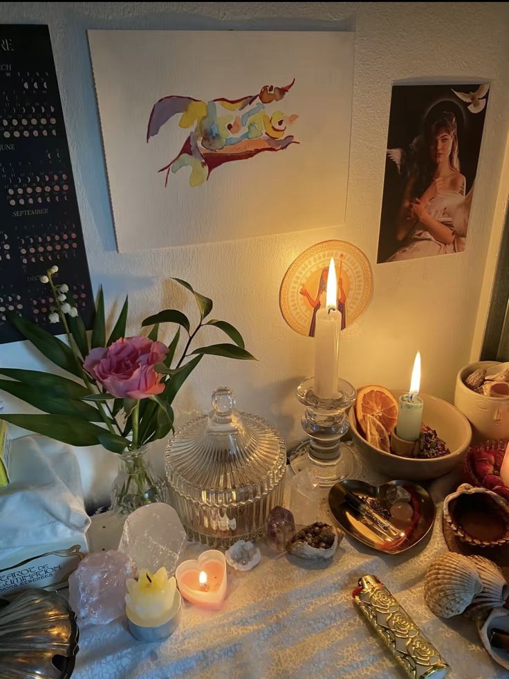 a table topped with candles and other items on top of a white cloth covered table