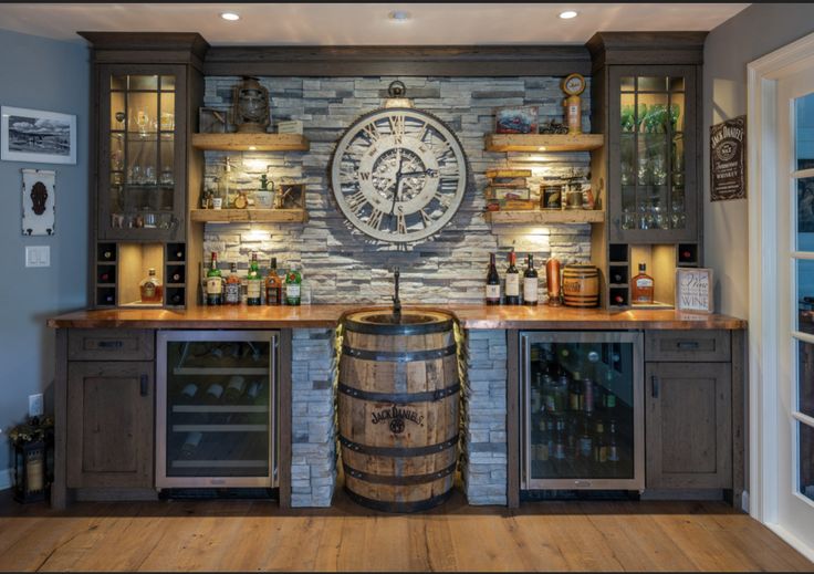 a large clock mounted to the side of a wall above a wooden barrel in a kitchen