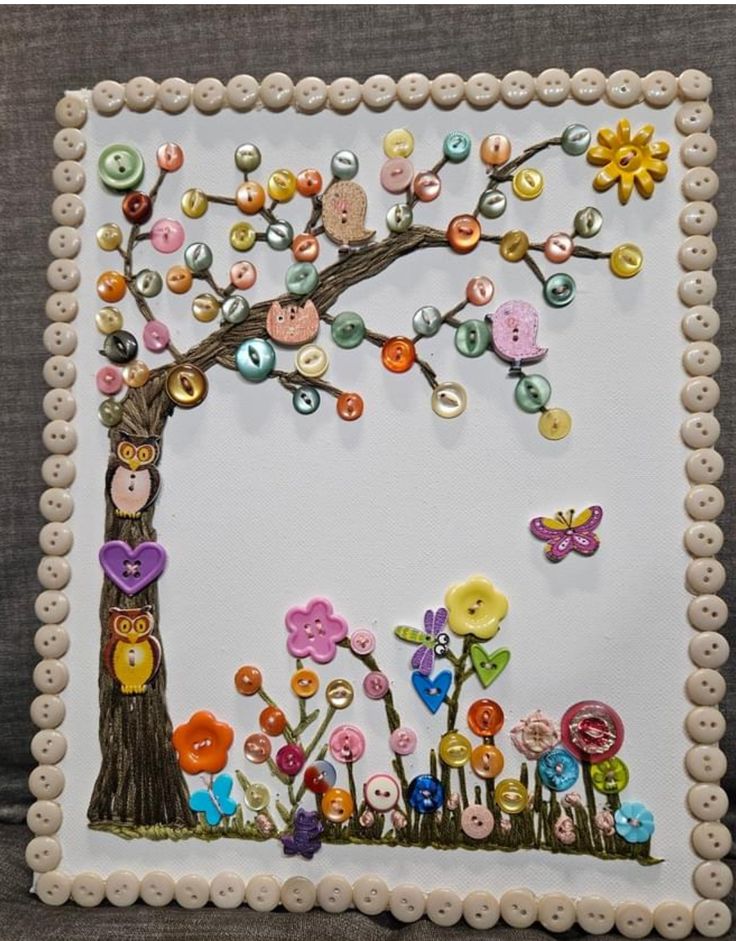 an art work with buttons and flowers in the shape of a tree