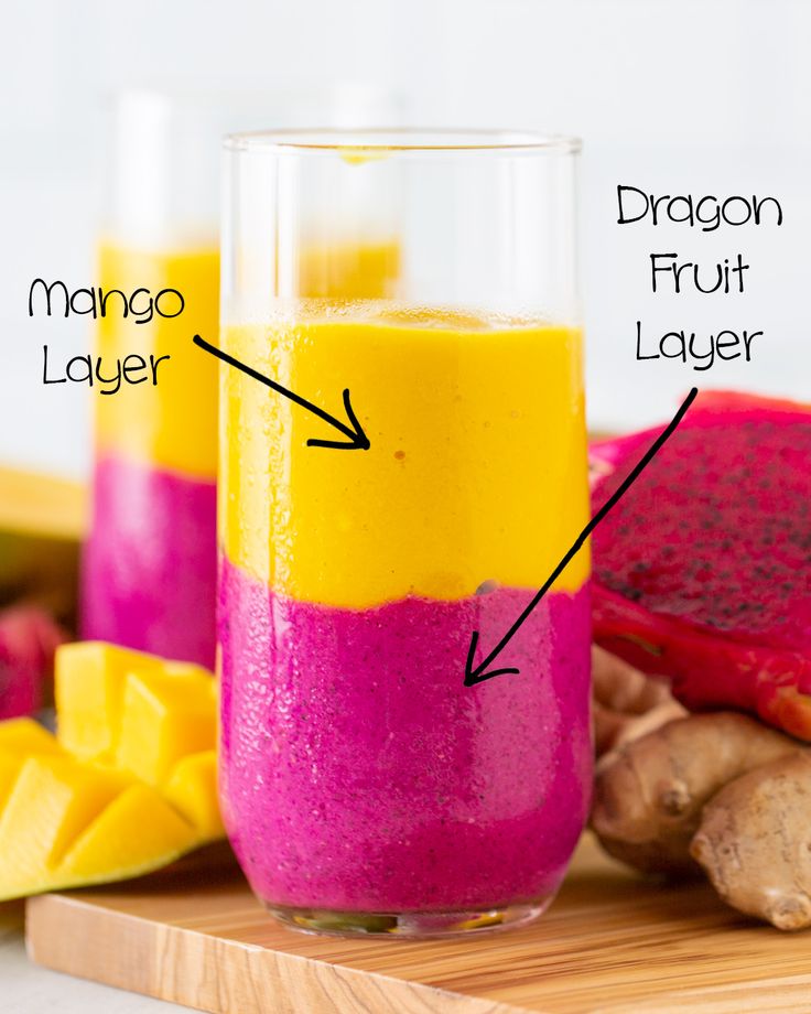 a smoothie in a glass with ingredients labeled on the top and bottom, including mango, dragon fruit, and ginger