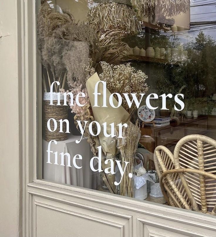 there is a window display with flowers in the front and behind it that says, fine flowers on your fine day