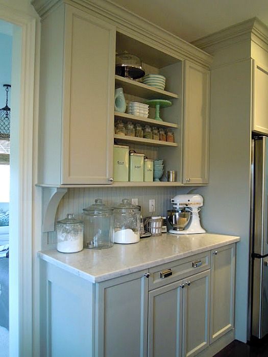 a kitchen with white cabinets and silver appliances