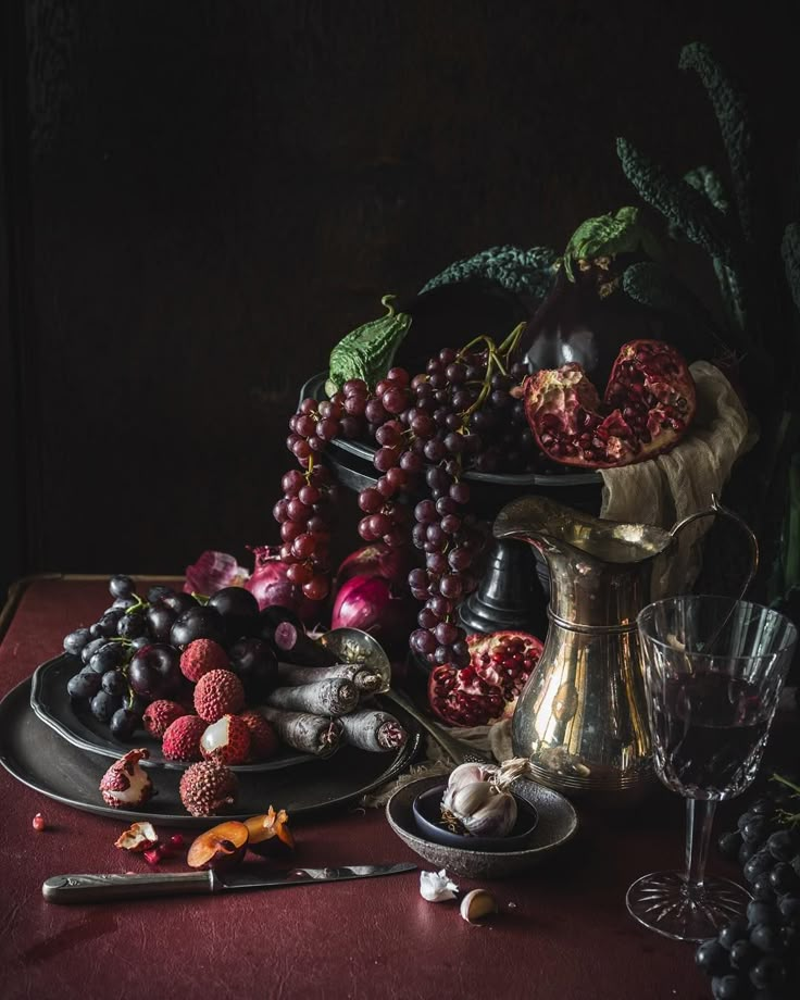 a still life with grapes, raspberries, and other fruit on a table