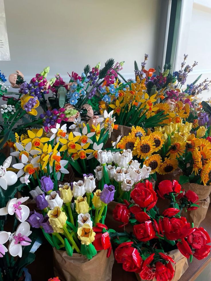 many different colored flowers in vases on a table