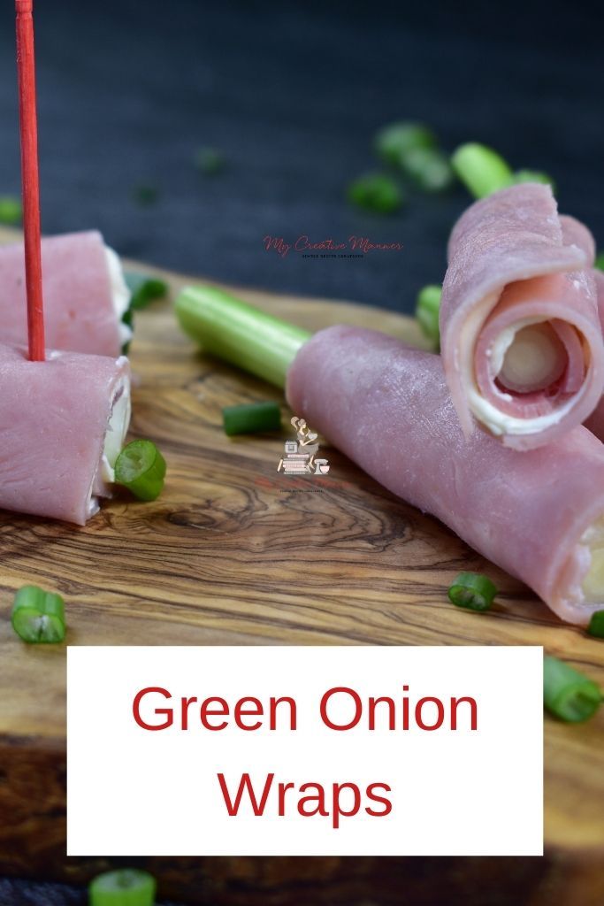 green onion wraps on a cutting board with toothpicks and celery in the background