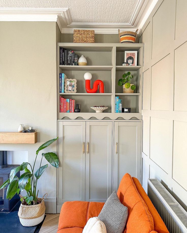 a living room with an orange couch and bookshelf