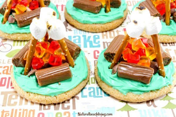 four cookies decorated with chocolate, marshmallows and pretzel toppings