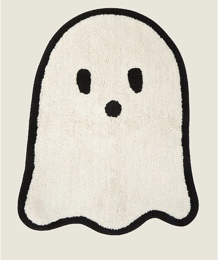 a black and white rug with a ghost face drawn on it's front side