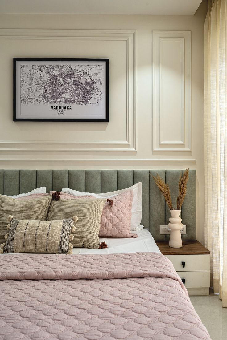 a bed with pink comforter and pillows in a bedroom next to a large window