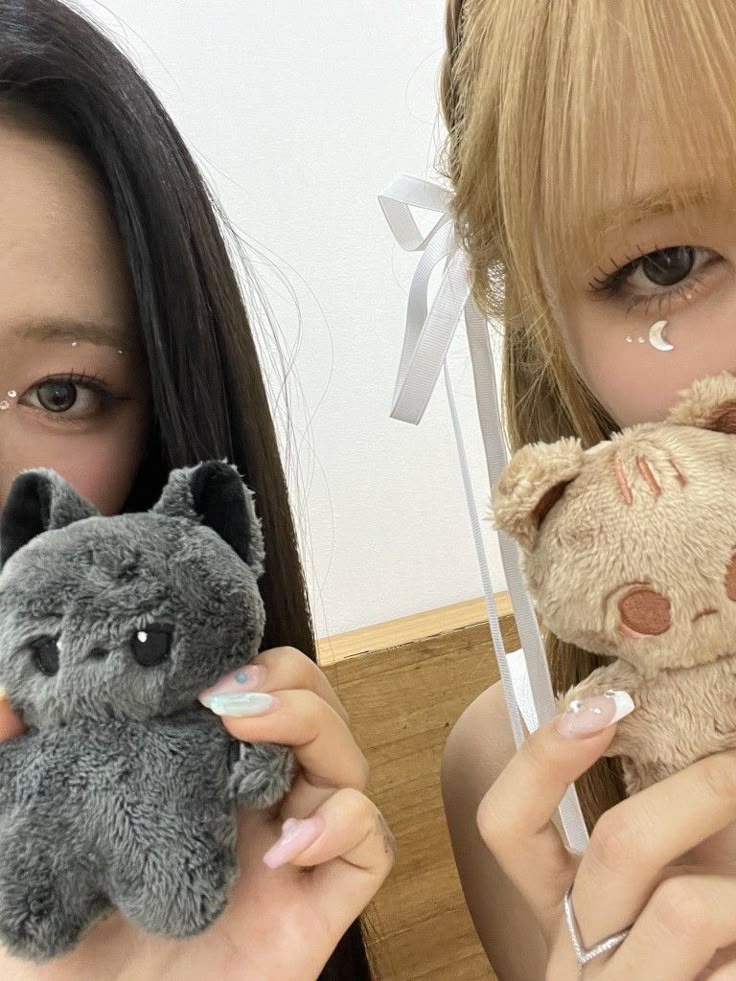 two girls holding stuffed animals in their hands