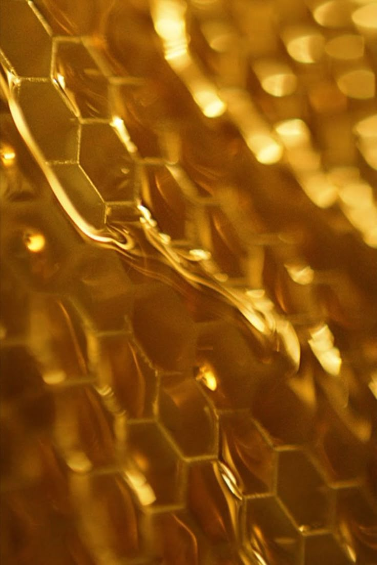 a close up view of honeycombs with the light reflecting off them in the background