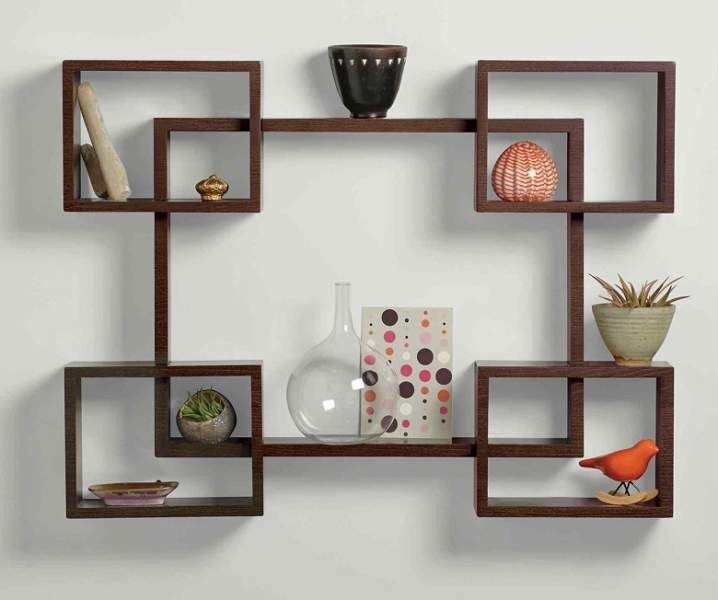 a wall shelf with various items on it and a vase in the corner next to it