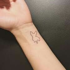 a person's wrist with a small tattoo of a bird on it and the outline of a dove