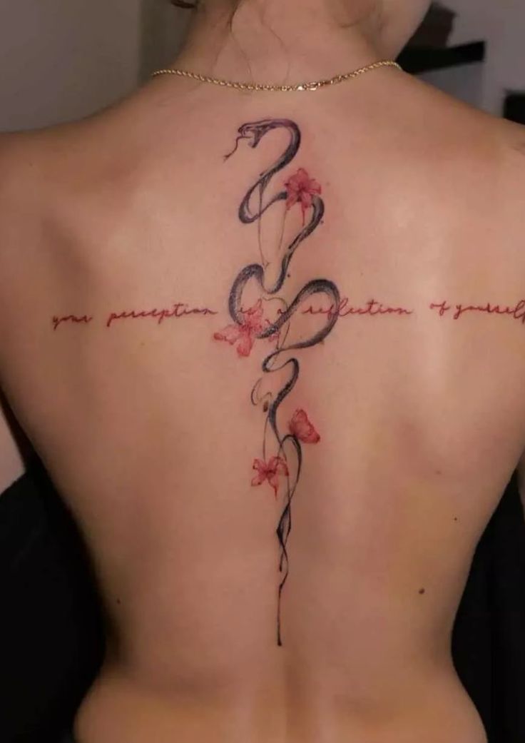 the back of a woman's neck with a cross and flowers tattoo on it