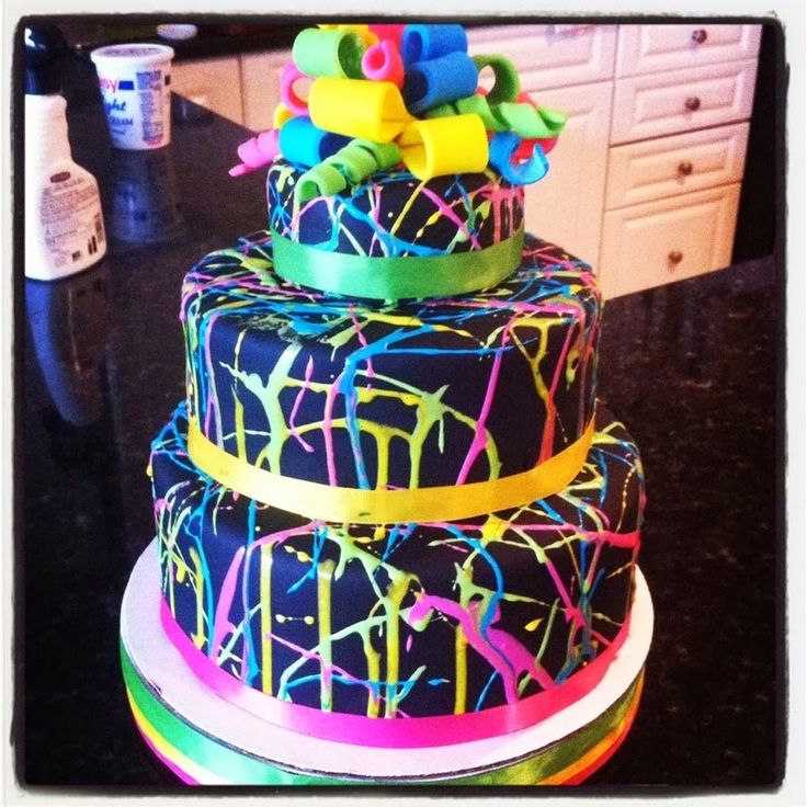 the cake is decorated with neon colors and ribbons