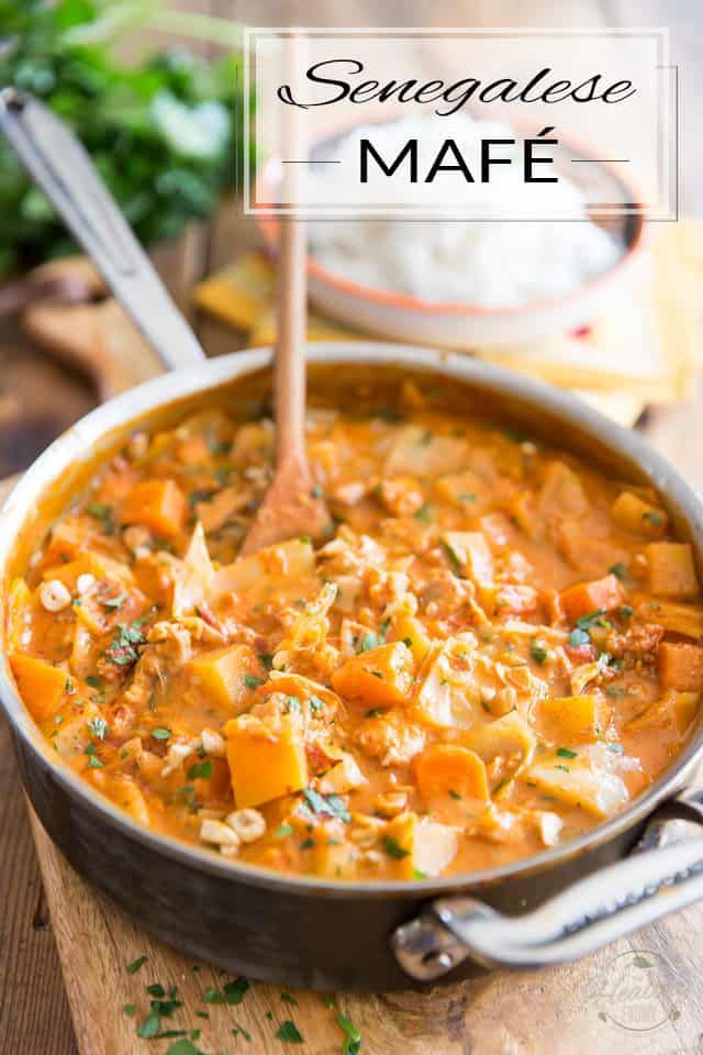 a large pot filled with stew on top of a wooden cutting board next to a knife