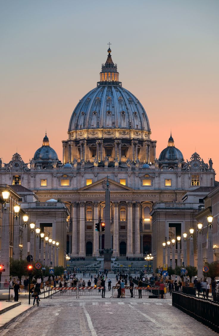 people are walking around in front of a large building with a dome on the top