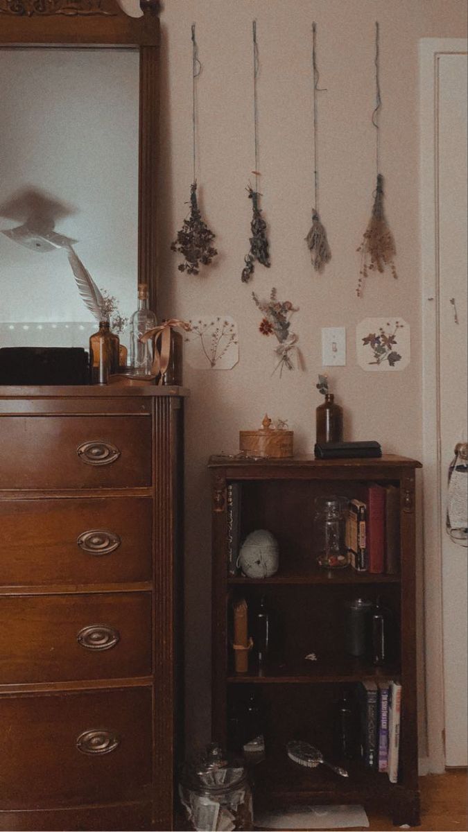 a dresser and mirror in a room with jewelry hanging on the wall next to it