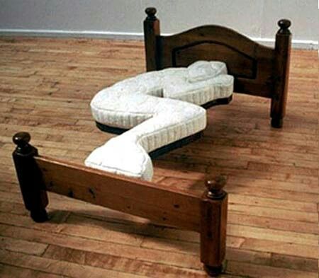 a wooden bed frame with two mattresses on it