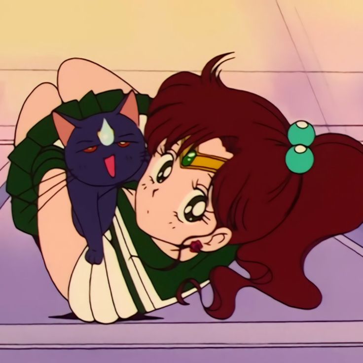 a woman laying on top of a floor next to a black cat with green eyes