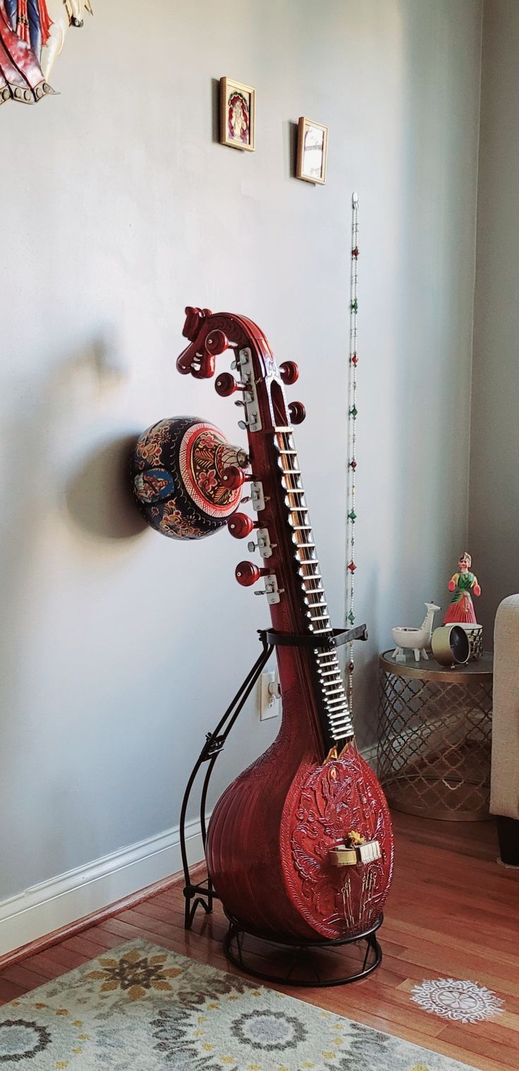 a red musical instrument sitting on top of a wooden stand