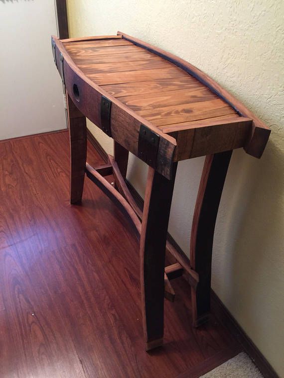 a wooden table sitting on top of a hard wood floor next to a white wall