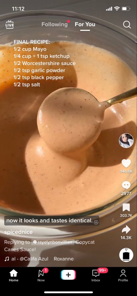 a spoon full of sauce in a bowl with the recipe on it's screen