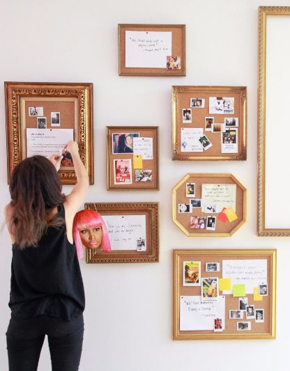 a woman standing in front of a wall with pictures on it