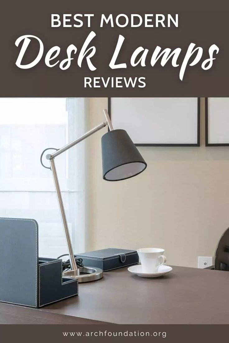 a desk lamp sitting on top of a wooden table next to a cup and saucer