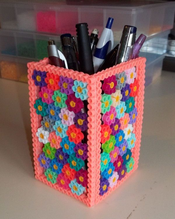 a plastic container filled with lots of pens and pencils on top of a table