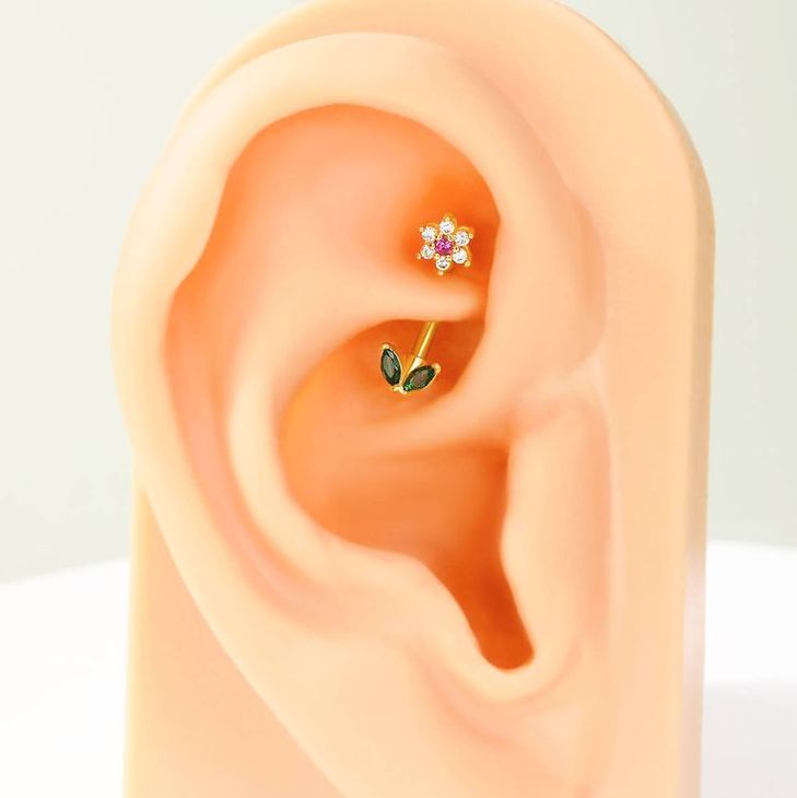 an ear is shown with two small leaves on it's side and one has a single flower in the middle