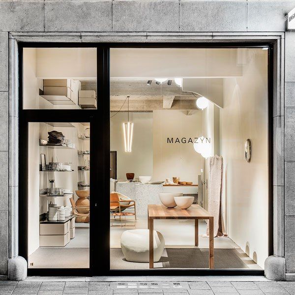 a store front with glass doors and white furniture