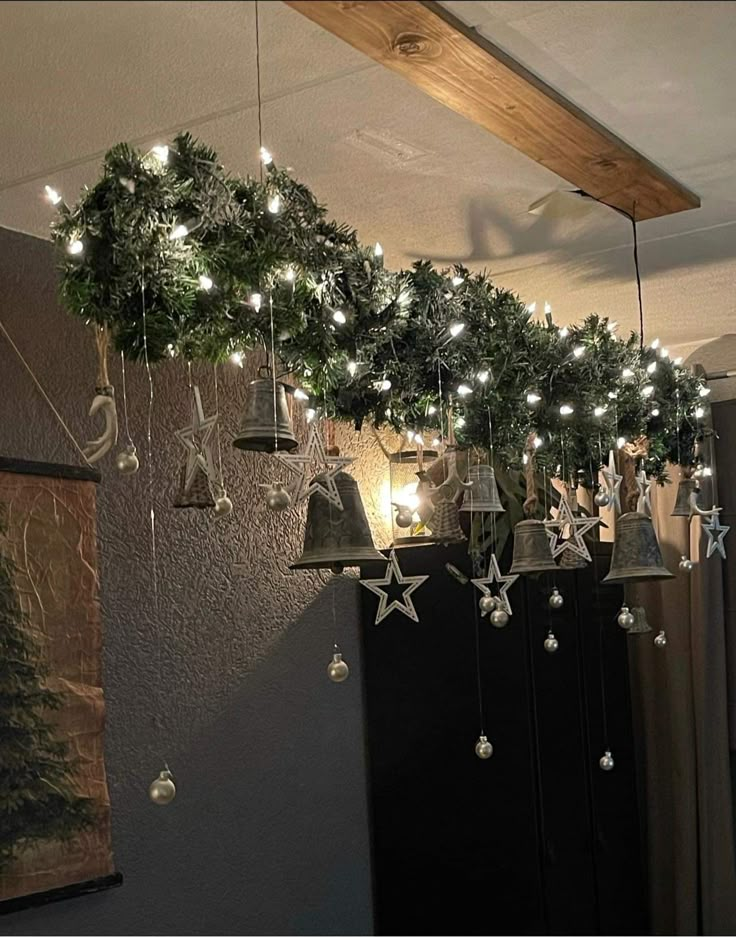 christmas decorations are hanging from the ceiling in front of a wall with lights and bells