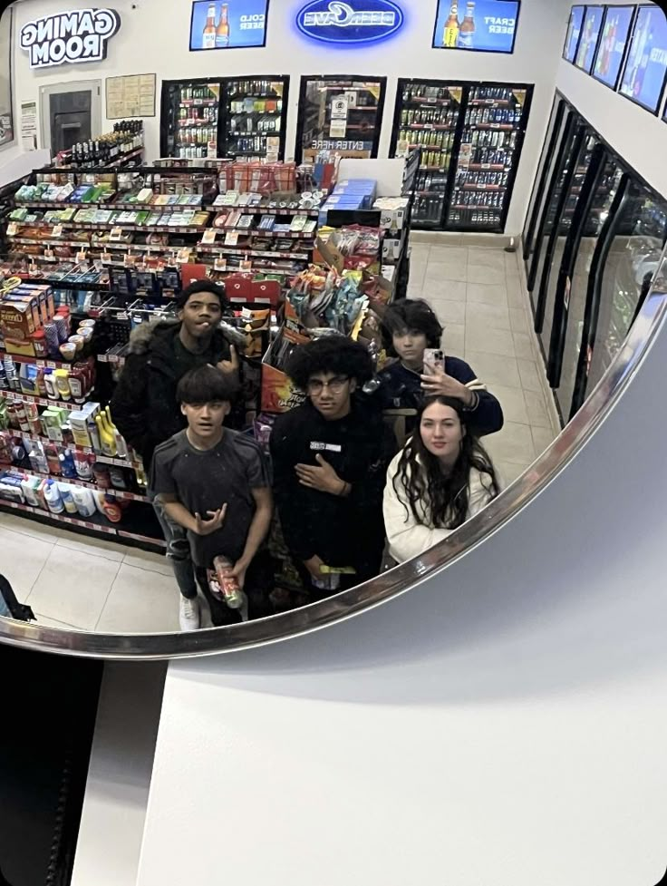 a group of people standing in front of a store looking at the camera through a fish eye lens