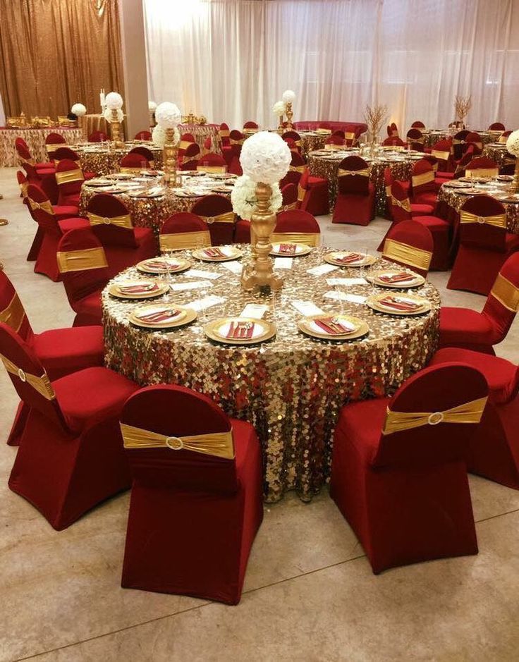 a banquet room set up with red chairs and gold table cloths