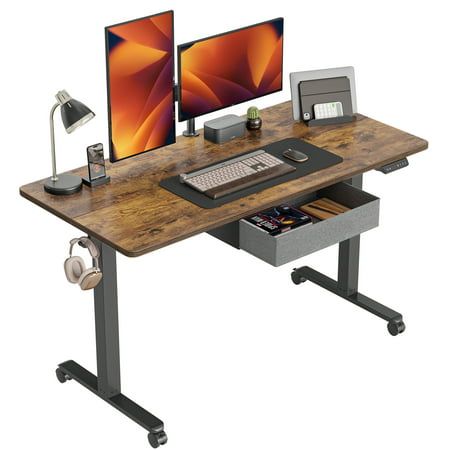 a computer desk with a monitor, keyboard and headphones on top of the desk