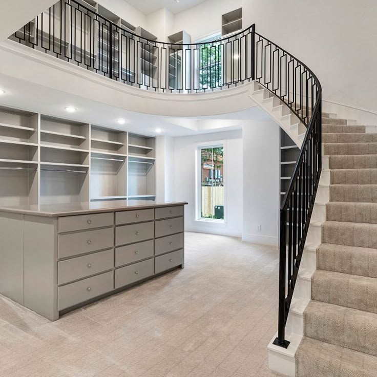 a large open floor plan with stairs leading up to the upper level and storage area