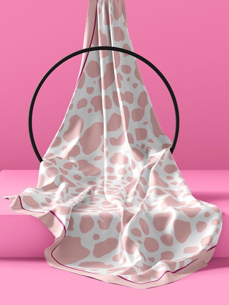 a pink and white blanket sitting on top of a table next to a black circle