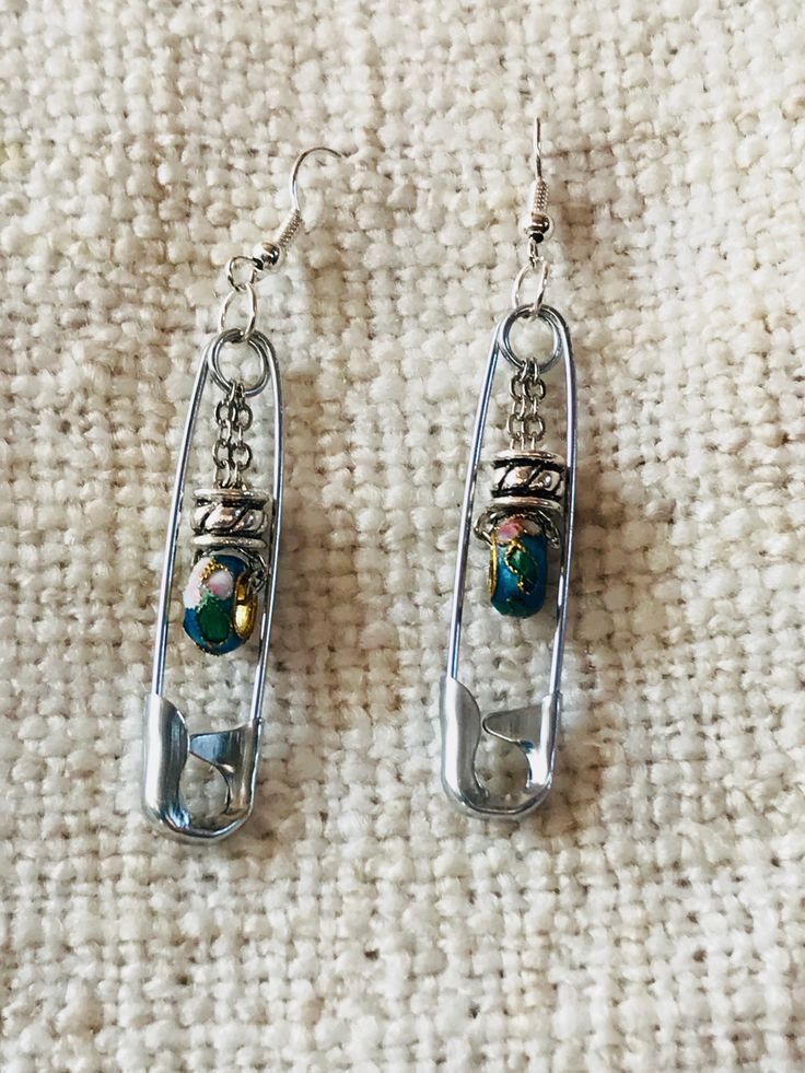 two pairs of earrings sitting on top of a rug