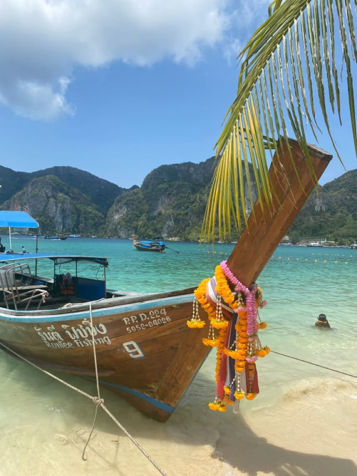 a boat is docked on the beach with other boats in the water